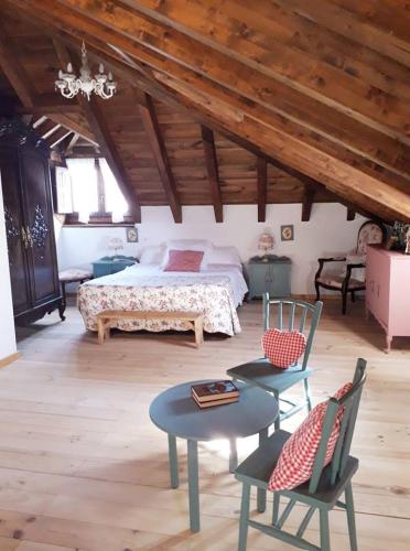 a bedroom with a bed and a table and chairs at Casa rural Nica in Arganza