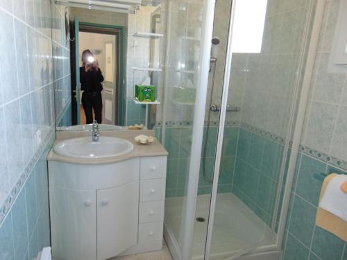 a person taking a picture of a bathroom with a sink and shower at LA MARVINIERE in Saint-Bonnet-sur-Gironde