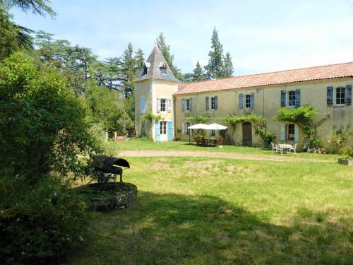 une grande maison avec une cour en herbe et une cour dans l'établissement Presbytère d'Arpentian, à Jégun