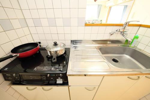 a kitchen with a stove with a pot on the stove at Near Nakajima park Close to Susukino Anbiennte 101 in Sapporo