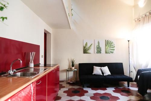 a kitchen with a sink and a couch in a room at Santamarta35 in Pisa