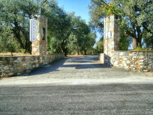 a stone wall next to a road with trees at Nemesis in Neo Klima
