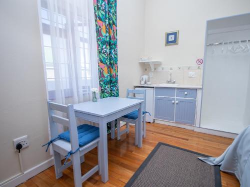 a small kitchen with a table and chairs in a room at Green Olive Guesthouse in Robertson