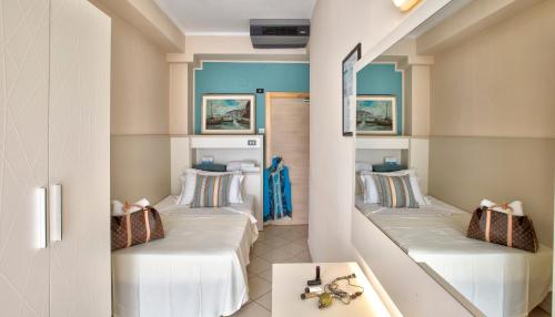 2 camas individuales en una habitación con mesa en Hotel La Residenza, en Riccione