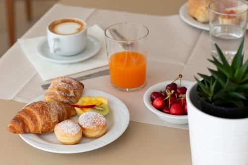 - une table avec un plateau de pâtisseries et une tasse de café dans l'établissement Hotel La Residenza, à Riccione