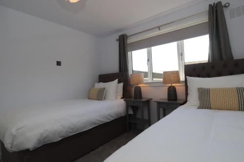 2 camas en una habitación con ventana en Dunfermline - Luxury 3 bedroom 2 bathroom detached house with garden, en Dunfermline