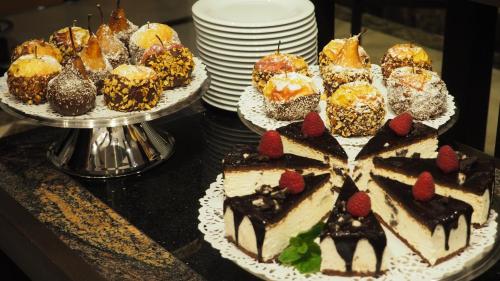 a table with several cakes and desserts on plates at Castelnor in Păltiniş