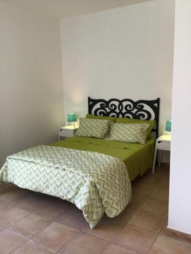 a bedroom with a bed with a green comforter and pillows at Charco Las Damas in Playa de San Juan