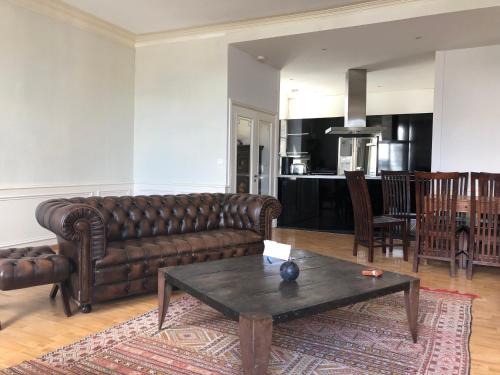 un salon avec un canapé en cuir et une table dans l'établissement hotel de Croix, à Morlaix