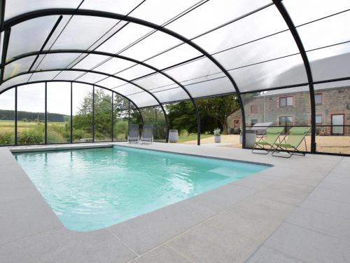 an indoor swimming pool with a retractable roof at Country house in the Ardennes with Schwimmbad in Warempage