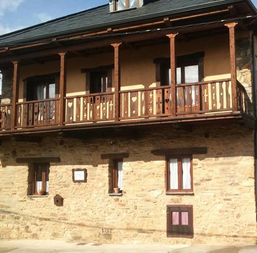 einen Holzbalkon an der Seite eines Gebäudes in der Unterkunft Casa rural Nica in Arganza