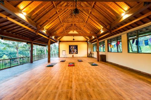 a large room with a large wooden floor and windows at Umasari Rice Terrace Villa in Tabanan