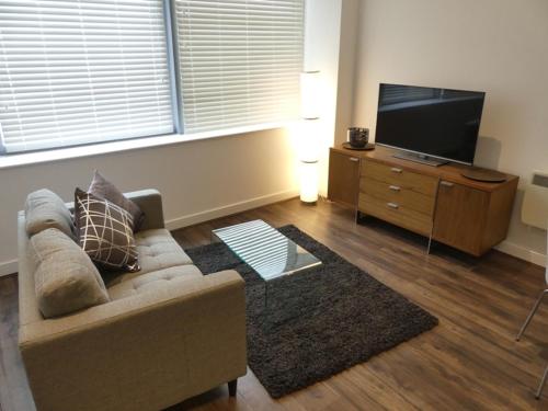 a living room with a couch and a flat screen tv at Churchill Place - Downtown Luxury Apartments in Basingstoke