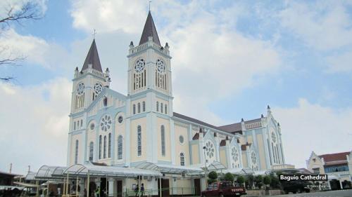 une grande église blanche avec une tour d'horloge dans l'établissement 3BU Hostel Baguio - Bonifacio, à Baguio
