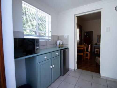 a kitchen with a counter top with a microwave at Green Olive Guesthouse in Robertson