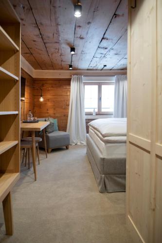 a bedroom with a bed and a table in a room at Pension Alpenfluh in Lech am Arlberg