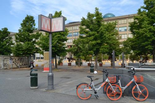 two bikes parked next to a metro sign on a street at DOMUS LINGOTTO in Turin