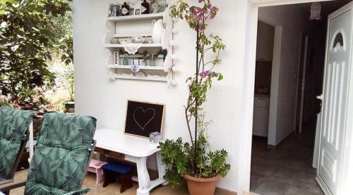 Faros oasis في Gdinj: غرفة مع طاولة مع الكمبيوتر المحمول والنباتات