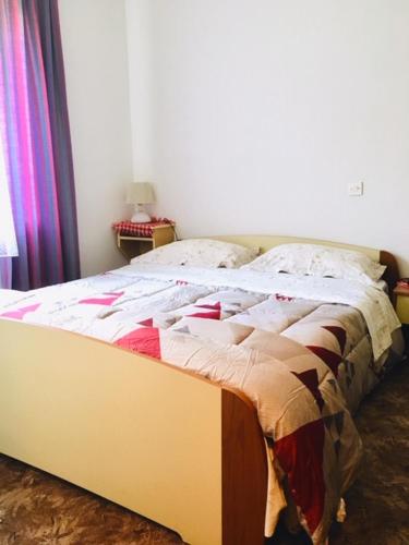 a bed sitting in a bedroom with a bedspread on it at Apartmaji Jana in Bovec
