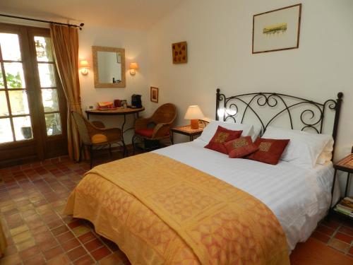 a bedroom with a bed and a table and chairs at Les Acanthes in Lauris