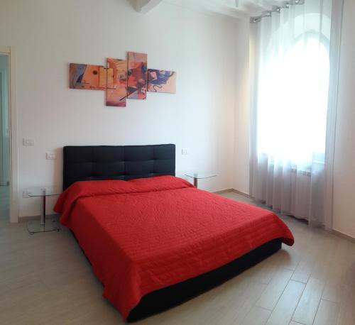チッタ・デッラ・ピエーヴェにあるVia delle Mura "Apt. Borgo Dentro"の赤いベッド1台(赤い毛布付)が備わるベッドルーム1室が備わります。
