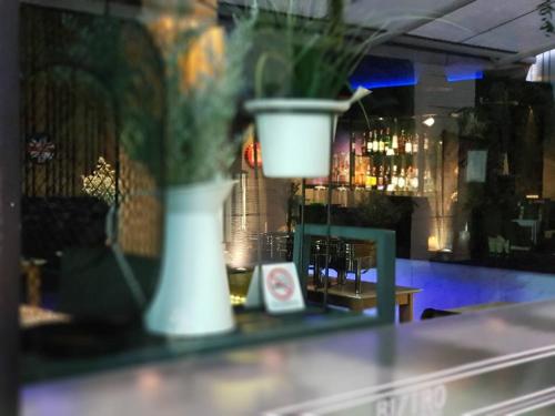 a white vase sitting on a counter in a bar at Bizotel Premier Hotel & Residence in Bangkok
