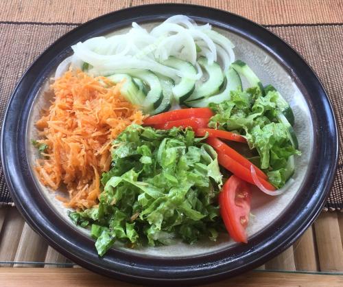 a plate of food with vegetables on a table at Kivu Beach Garden in Gisenyi
