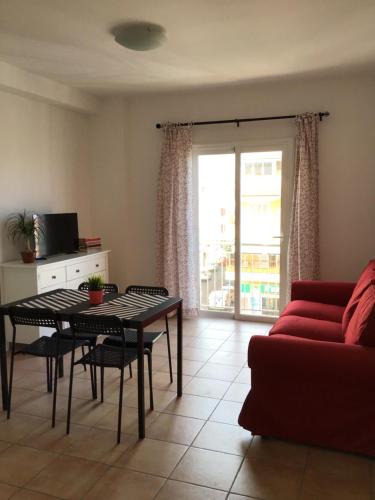 - un salon avec une table et un canapé rouge dans l'établissement Tarajal de Playa, à Playa de San Juan