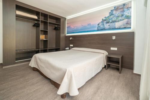 
a hotel room with a bed and a desk at Hotel Prado II in Peniscola
