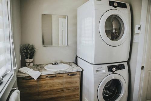 a bathroom with a washing machine and a sink at Chalet Mathis in Saint-Raymond