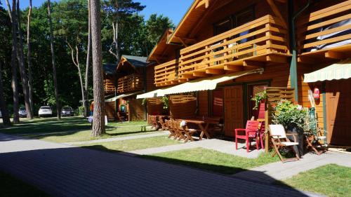a building with a table and chairs and a patio at NATURA PARK Ustronie Morskie - domki, apartamenty in Ustronie Morskie