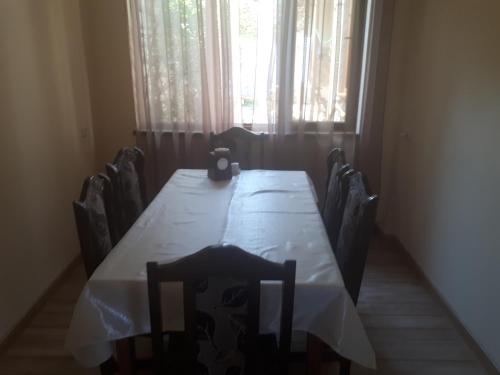 a dining room table with chairs and a window at Hotel VIVAS in Goris