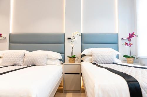 2 camas en una habitación de color blanco y azul en NOX West Hampstead en Londres