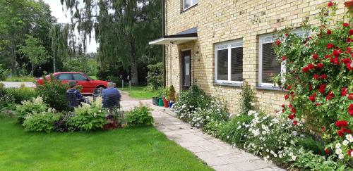 a house with a garden with flowers in the yard at Bo hos Nancy i Ölme in Kristinehamn