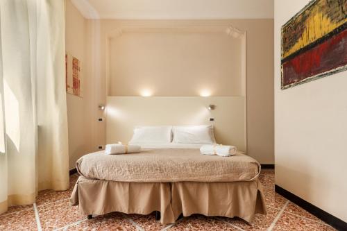 a white bed sitting in a room next to a wall at Lucca In Villa Elisa & Gentucca in Lucca