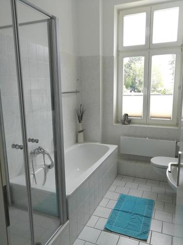 a white bathroom with a tub and a window at Ferienwohnung Sundkieker in Stralsund