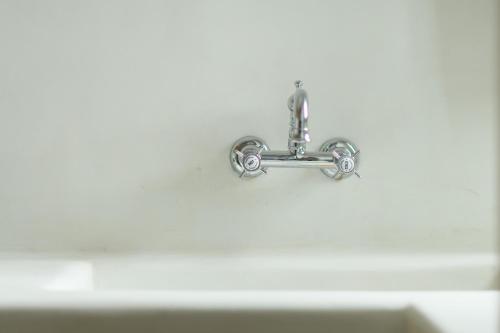 a bathroom sink with a faucet on the wall at The Summit of Mykonos in Kalo Livadi