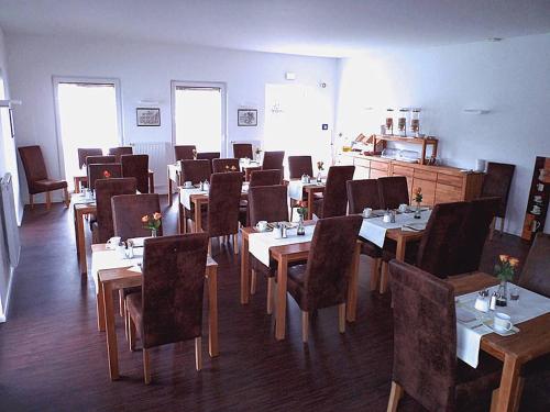 une salle à manger avec des tables et des chaises dans un restaurant dans l'établissement Das Neue Hotel Am Park, à Fröndenberg/Ruhr