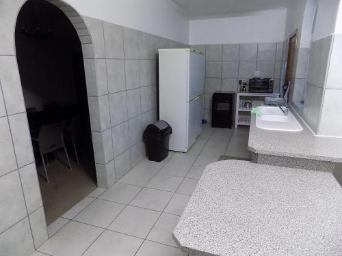 uma cozinha com um frigorífico branco e um lavatório em Haka Hana B&B The Farm House em Port Elizabeth