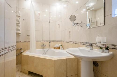 La salle de bains est pourvue d'une baignoire et d'un lavabo. dans l'établissement OhMyHome - Kościuszki, à Łódź