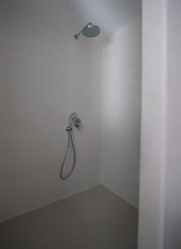 a shower in a white room with a shower head at The Summit of Mykonos in Kalo Livadi