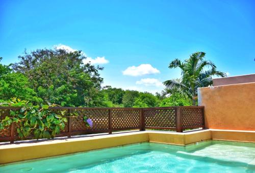 a swimming pool on a balcony with a fence and trees at Vipingo Ridge-Swahili Villa in Mombasa