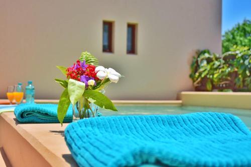 a vase of flowers on a table next to a swimming pool at Vipingo Ridge-Swahili Villa in Mombasa