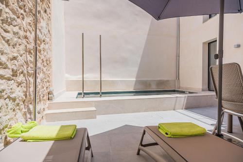 a room with two chairs and an umbrella and a tub at CASA OASIS in Pollença