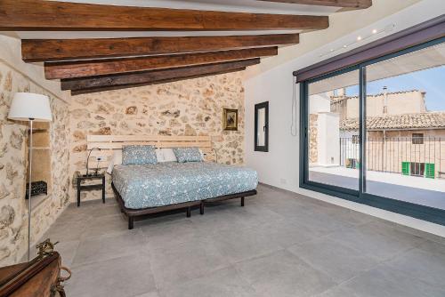 a bedroom with a bed and a large window at CASA OASIS in Pollença