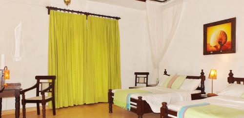 a bedroom with two beds and a green curtain at Vipingo Ridge-Swahili Villa in Mombasa