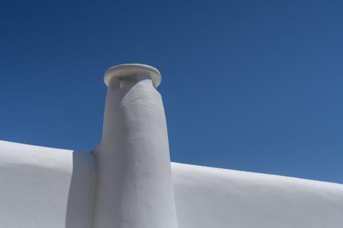 a white pole with a blue sky in the background at The Summit of Mykonos in Kalo Livadi