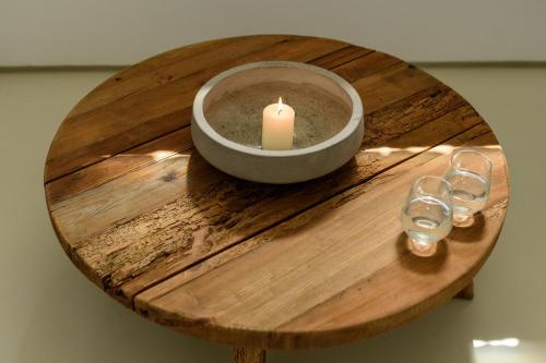 a candle and two glasses on a wooden table at The Summit of Mykonos in Kalo Livadi