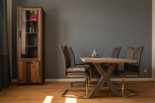 een eettafel met stoelen en een boekenplank bij Ferienwohnung Sundkieker in Stralsund