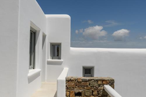 a white house with a window and a stone pillar at The Summit of Mykonos in Kalo Livadi